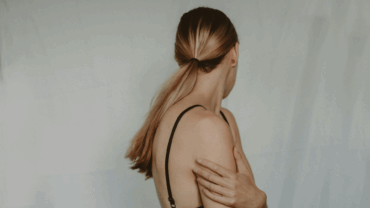 Woman looking away from the camera while holding herself.