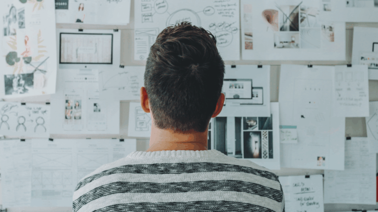 Entrepreneur organizing his business by looking at his productivity system wall