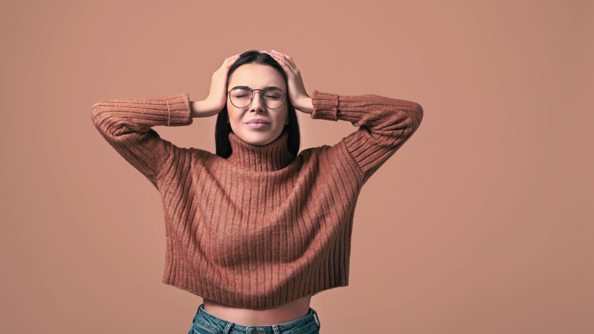 Young woman holding her head in frustration due to her anxiety.